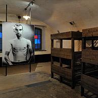 Foto van gevangene en houten stapelbedden in het Fort van Breendonk, België
