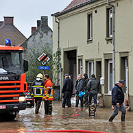 Brandweerauto in overstroomde straat met zandzakjes voor de huizen, Nederzwalm, Vlaamse Ardennen, België

